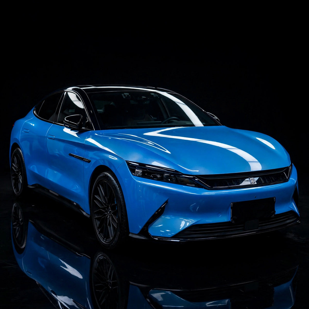 Super Gloss Coral Blue PET vinyl wrap film on a car, front three-quarter studio view