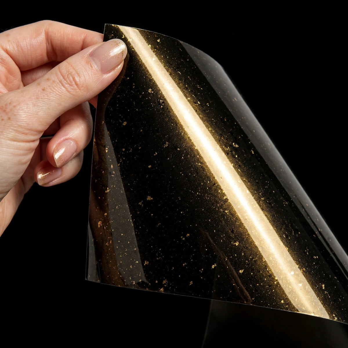 Super Gloss Black Gold Metallic vinyl wrap film sheet held in hand