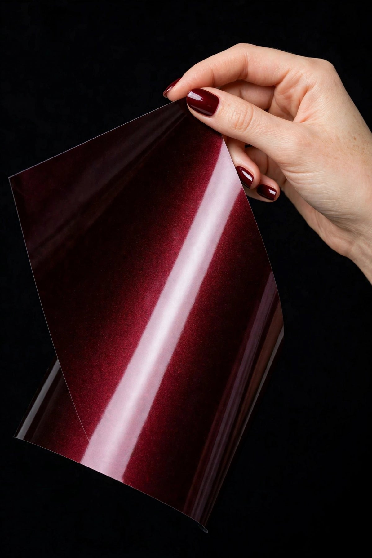 Super Gloss Pearl Black Red vinyl wrap film sheet held in hand