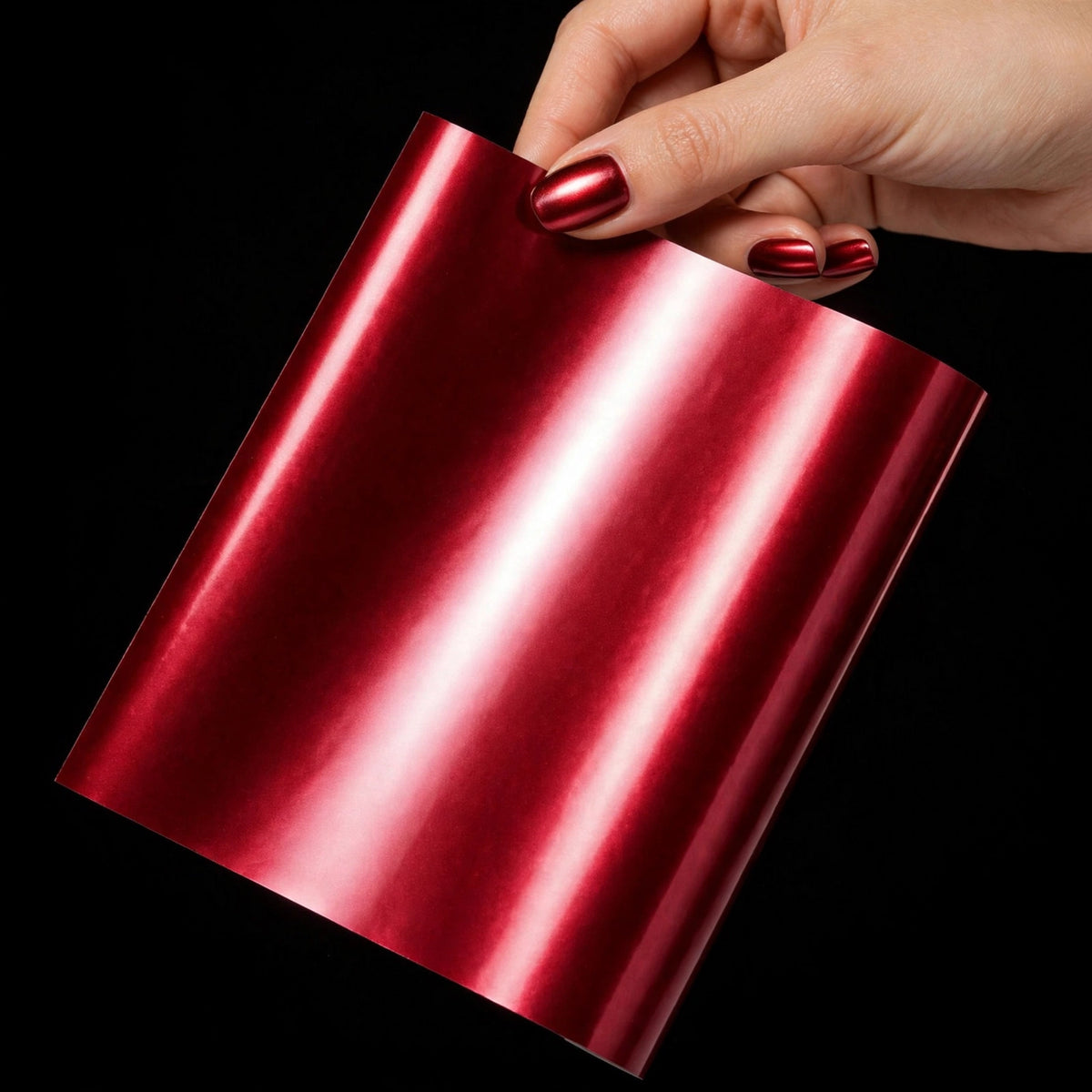 Chrome Romani Red vinyl wrap film sheet held in hand