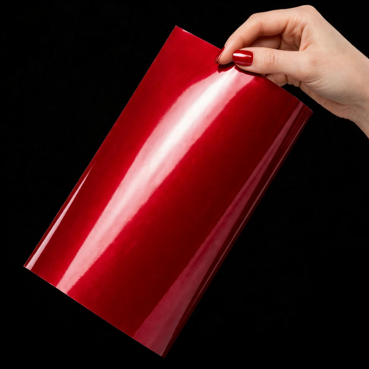 Super Gloss Liquid Ruby Red vinyl wrap film sheet held in hand